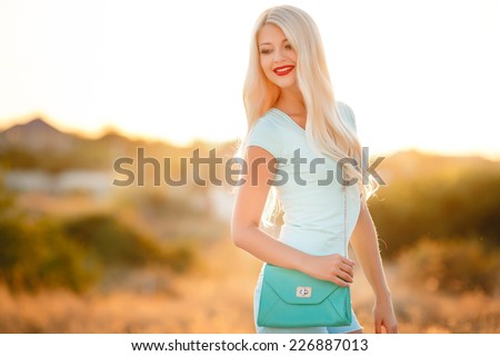 Young and beautiful woman wearing a hat in sunset light. Happiness woman stay outdoor under sunlight of sunset
