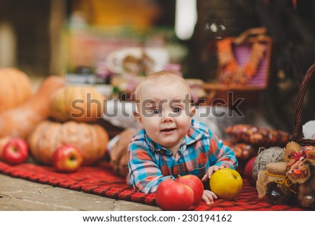 Happy child on autumn orange leaves, pumpkins.Outdoor. Infant in autumn garden. Autumn decorations