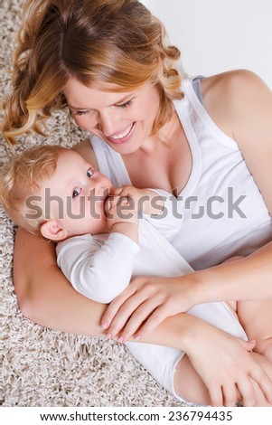 Portrait of nice boy with mother, little baby with mommy isolated on white background, pretty woman and cute cheerful child play game, happy smiling young lady hugging son, new family and love concept