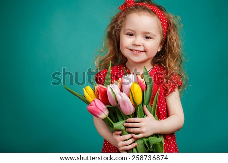 Cute little girl holding tulip bouquet. Studio portrait. Girl with tulips. Mother\'s Day, March 8, International Women\'s Day.