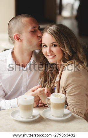 Happy man and woman in cafe. Loving couple on date at cafe. Two people in cafe enjoying the time spending with each other. Couple in cafe drinking coffee latte and smiling. Happy couple