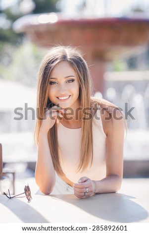 Young smiling woman outdoors portrait. Soft sunny colors.Close portrait. beautiful smiling girl. Woman in the city in summertime. Summer outdoor portrait