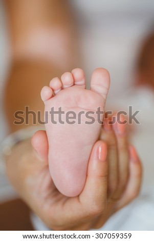 newborn baby feet on female hands. Baby feet in mother hands. A close-up of tiny baby feet. newborn baby feet. Baby feet in mommy\'s hands. mother with child