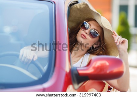 happy young woman in car driving on the road. Summer car travel freedom woman with arms raised up cheerful and happy. Summer road trip traveler concept.