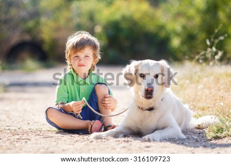 Little boy with a golden retriever dogs outdoor. Boy with a dog on the nature