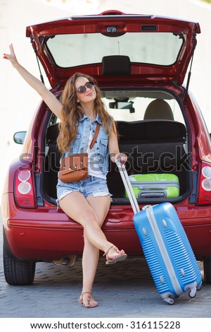 one young woman alone with suitcases. Vacation concept. Car trip. Summer vacation. girl posing with her luggage. woman traveling with suitcases, walking on the road