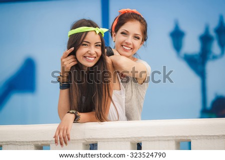 girls friends laughing and outdoor. Young pretty hipster girls friends having fun outdoor in summer on the street. Vintage lifestyle trendy portrait.Two women friends laughing
