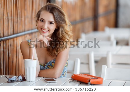 pretty young woman sitting in the cafe with a cup of tea. Charming woman in a restaurant. woman drinking coffee in the morning at restaurant (soft focus on eyes)