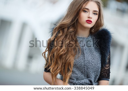 fashion outdoor photo of beautiful lady with dark hair wearing elegant coat,leather gloves and felt hat,posing in autumn park. Beautiful fashionable woman standing on the city street.