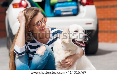 woman with dog by car full of suitcases. car trip. Woman and dog in car on summer travel. getting ready for road trip.