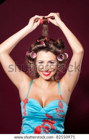 Portrait of a beautiful girl in studio with hair rollers