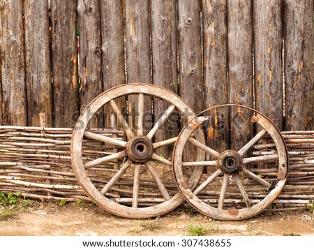 Wheels in the yard of wooden log house in Russian village in the middle Russia