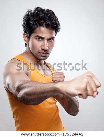 Handsome Indian man giving a knockout punch