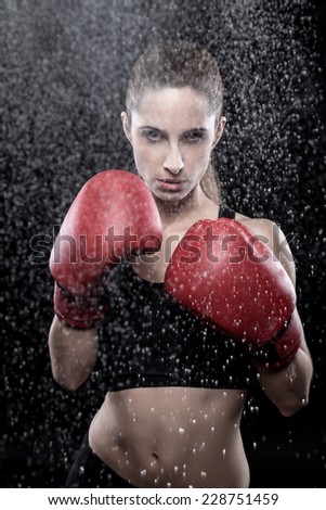 Beautiful woman in great shape wearing boxing gloves