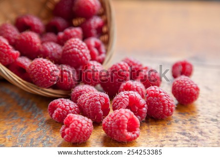 Fresh and tasty looking raspberries on a wooden table