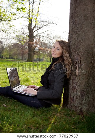 Woman sitting in park with a new laptop
