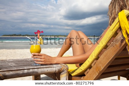 Woman enjoying a cocktail on a tropical beach