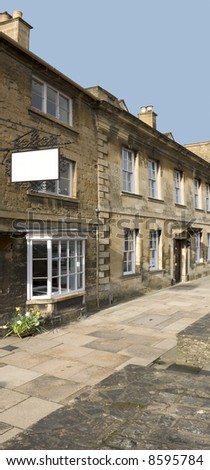 A row of old stone houses with a blank white sign.