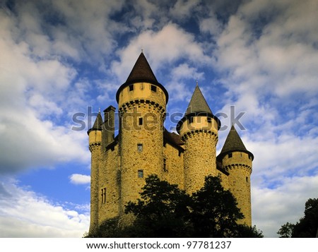 a fairy tale castle with turrets against a sky with white clouds