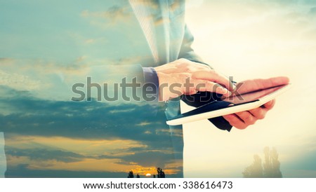 Double exposure of businessman typing on tablet screen, sunrise clouds background