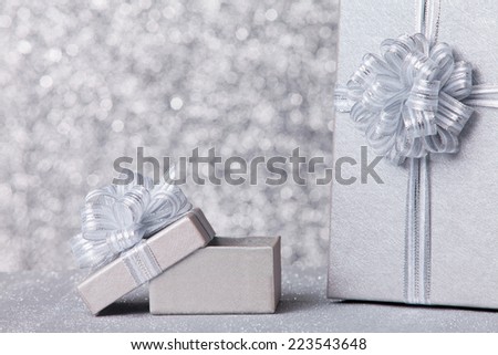 gift boxs with silver ribbon, glittery silver background