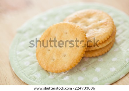 Round salty crackers on white dot green fabric  background