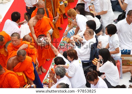 BANGKOK , THAILAND - MARCH 18: People Gives food offerings to a Buddhist monk on March 18, 2012 in Bangkok, Thailand. Thai traditional, people will make merit making by give food to monk