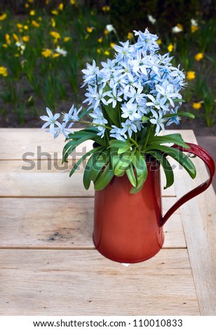blue delicate bouquet of flowers in red metal vase