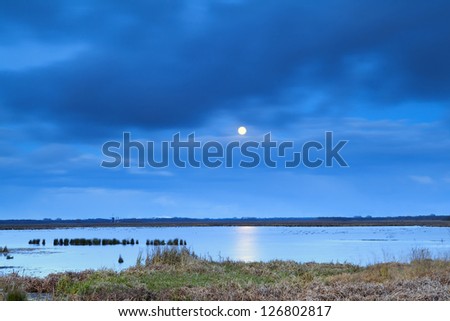 full moon at night over lake with long exposure