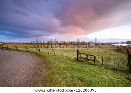 dramatic sunrise over road and fence