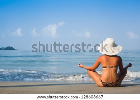 meditation, woman in hat on the beach