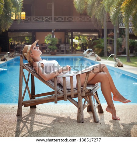 lazy day, idleness, woman sleeping in the deck chair near the swimming pool