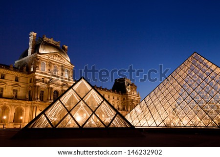 PARIS - APRIL 25: Louvre Pyramid shines at dusk on April 25, 2013 in Paris. Louvre is the biggest Museum in Paris displayed over 60,000 square meters of exhibition space.