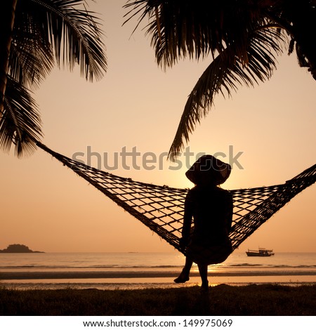 Woman In Hammock Enjoying Sunset On The Beach