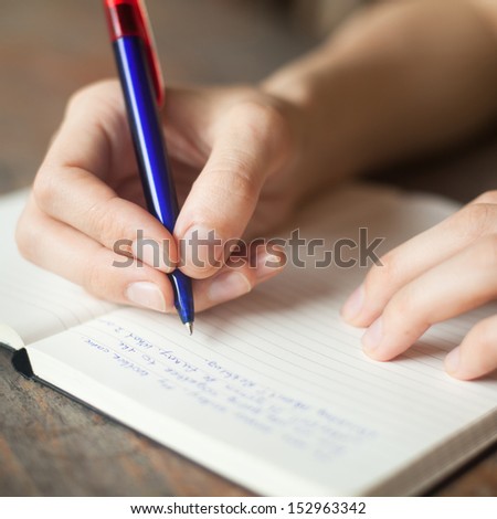 Hands Writing In The Notepad