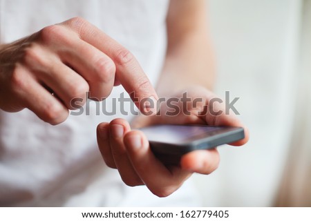 man hands touching smartphone bright background, closeup