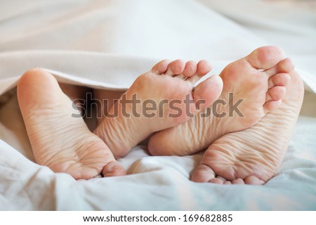 feet of couple in the bed