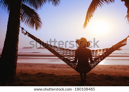 relaxing in hammock at sunset on the paradise beach