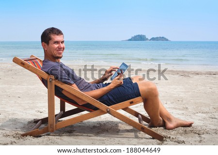 banking online, portrait of happy business man with tablet on the beach