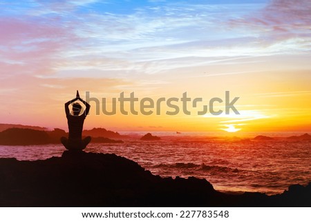 woman meditating at sunset, silhouette of person practicing yoga, mental health concept