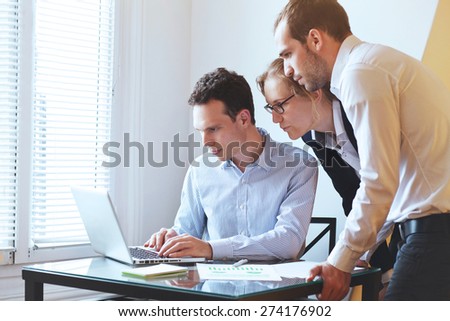 group of young business people looking at the screen of computer