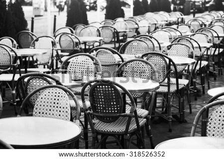 vintage street cafe in Paris, black and white photo of wicker chairs and tables