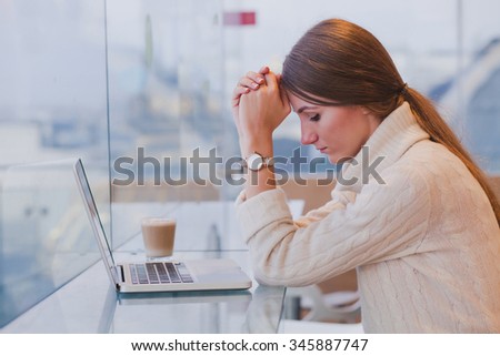 unemployment concept, problem, sad tired woman in front of laptop in modern bright cafe interior