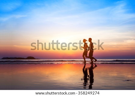 workout background, two people jogging on the beach at sunset, runners silhouettes, healthy lifestyle concept