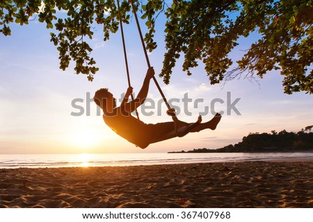 swing on paradise tropical beach at sunset, happy people enjoying summer