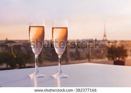 two glasses of champagne at rooftop restaurant with view of Eiffel Tower and Paris skyline, luxury romantic dinner for couple