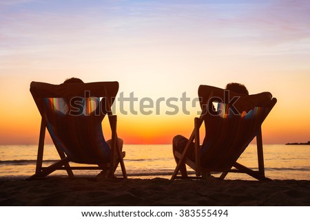 enjoy life concept, couple relaxing in beach hotel at sunset, happy people on honeymoon, paradise travel destination