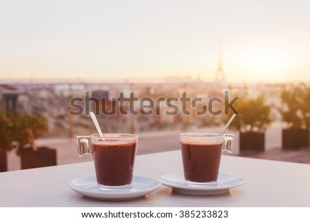 two cups of coffee or hot chocolate and Paris skyline at sunset, cafe with panoramic view of the city with Eiffel tower