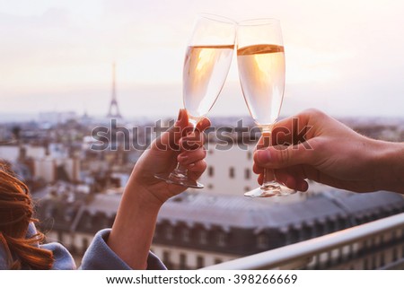 two glasses of champagne or wine, couple in Paris, romantic celebration of engagement or anniversary
