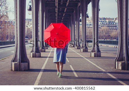 fashion woman with red umbrella walking on the street in Paris